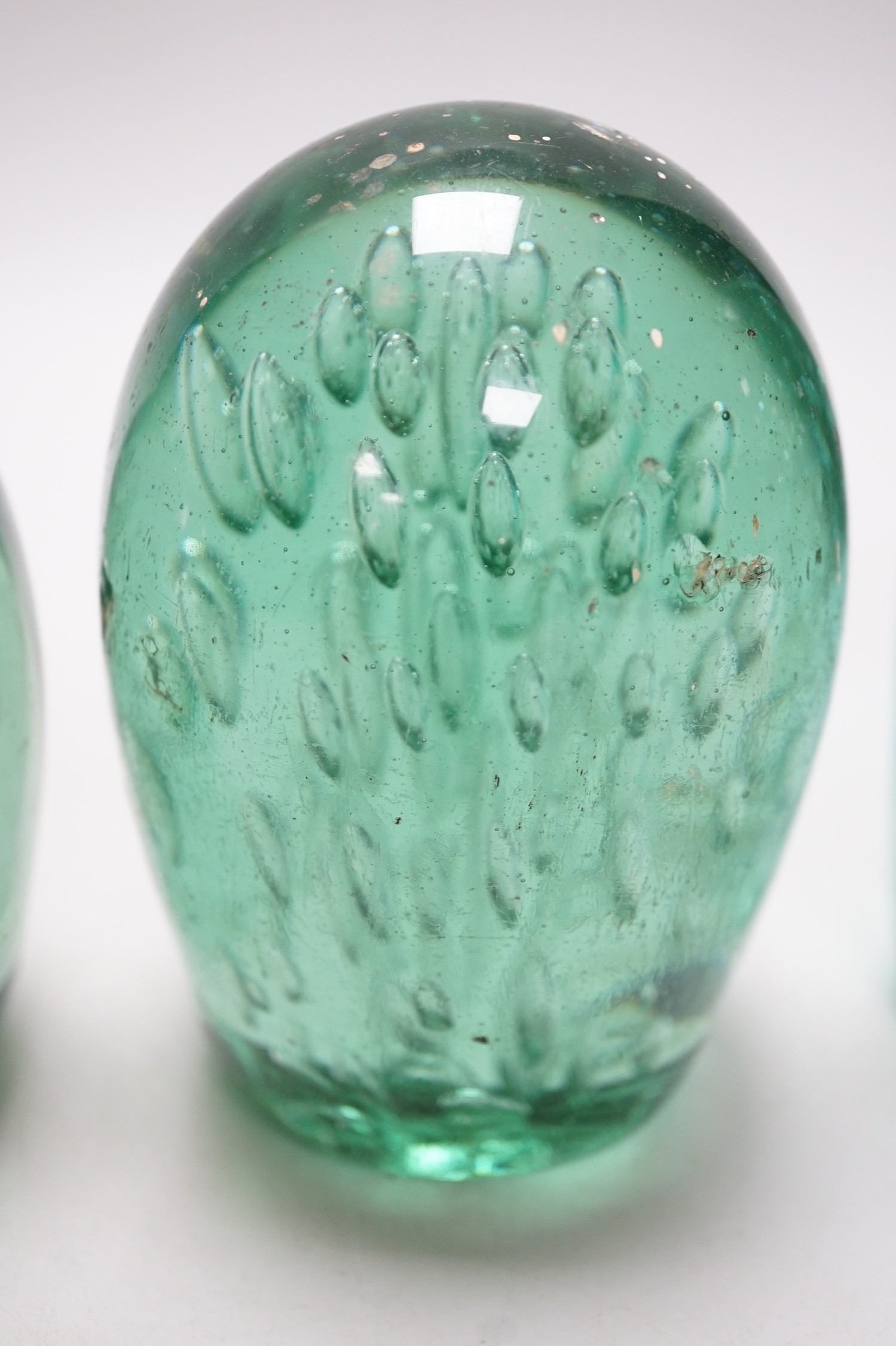 Four 19th century green glass dumps, one floral, tallest 16cms high